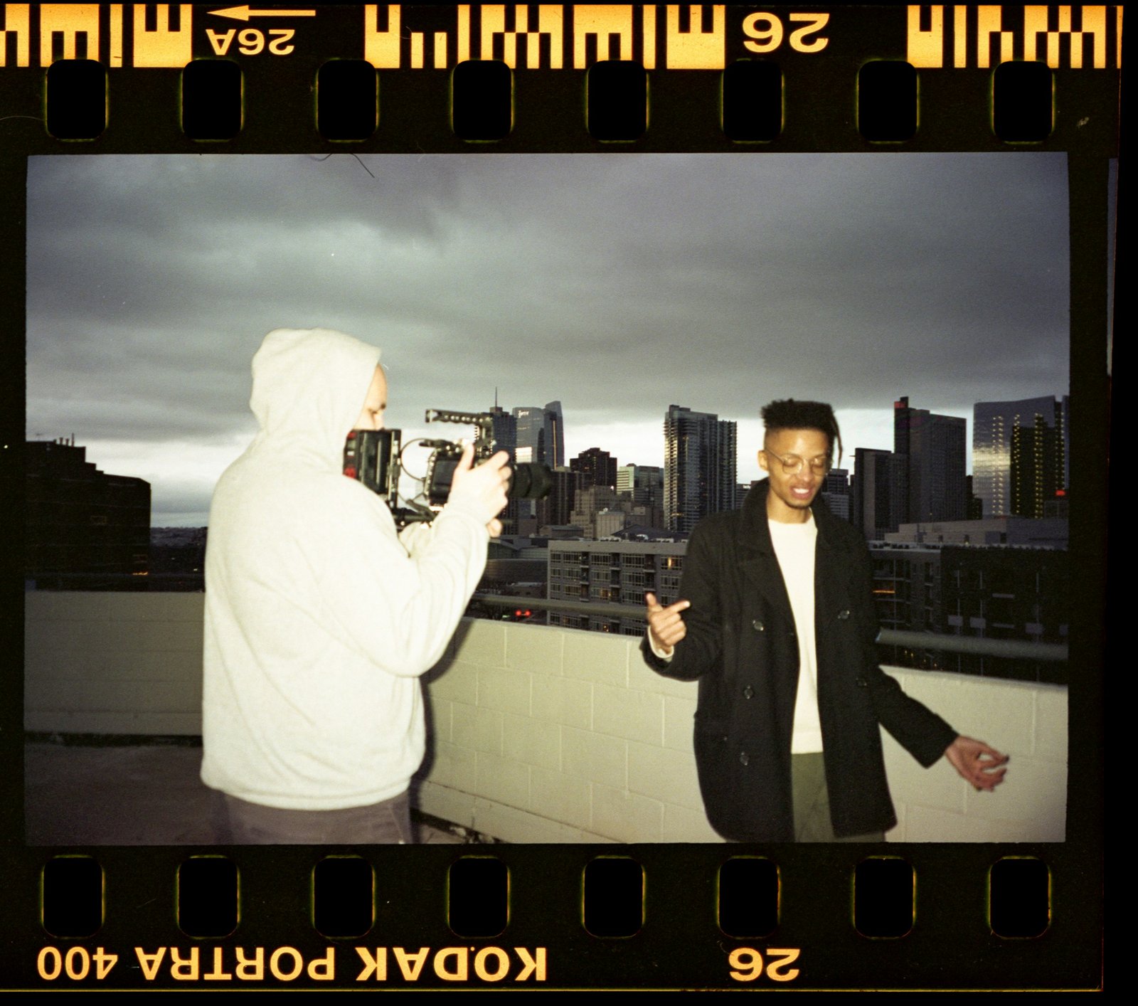 man in black suit standing beside man in white thobe